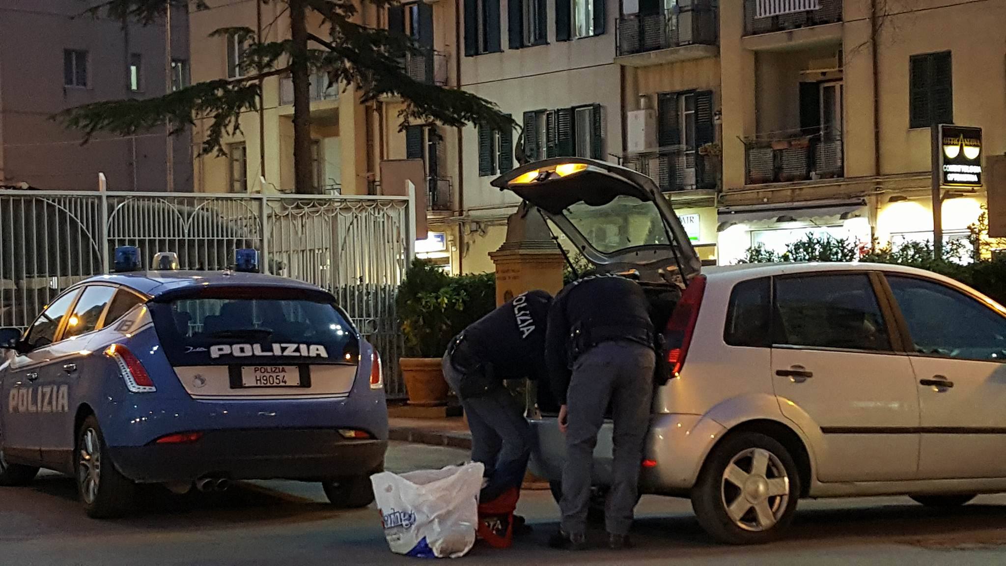 I poliziotti che perquisiscono l'auto di uno dei due arrestati