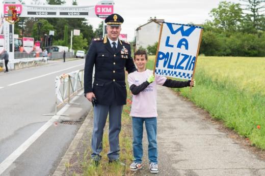 “Grazie per quello che fate per noi”. Piccolo spettatore ad una tappa del giro d’Italia ringrazia la Polizia di Stato.